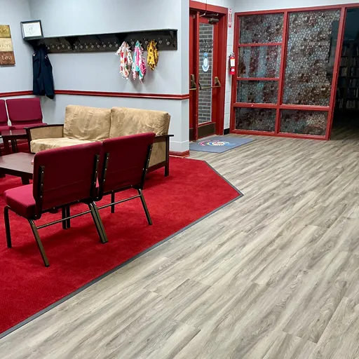 Salvation Army entryway and sitting area with wood look floors and red carpets